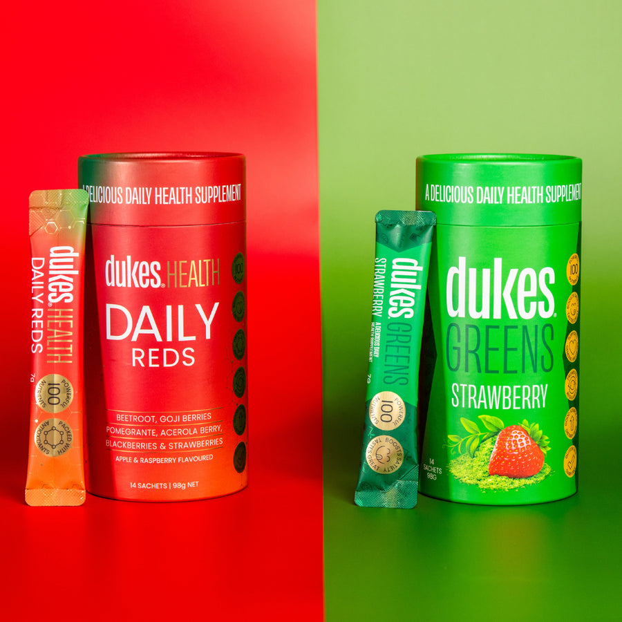 Half split vertical image with Tubes of Dukes Daily Reds on the left and Dukes Greens Strawberry Flavour on the right. 