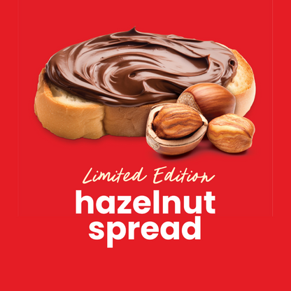 A piece of bread with hazelnut spread on top of it next to hazelnuts