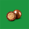 One and a half chocolate malt balls open half facing frontwards, on a green background