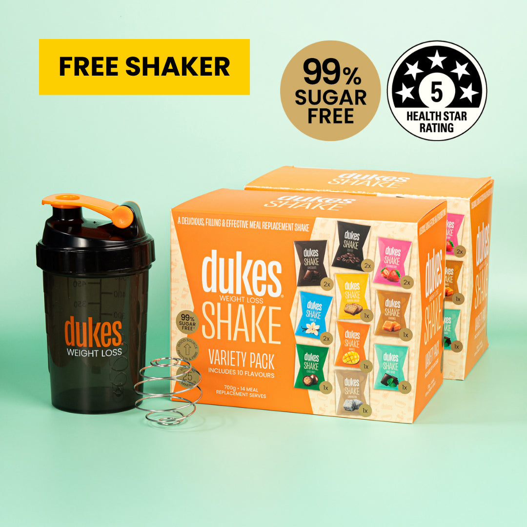 Two Dukes Shake Variety Packs next to a Dukes Protein Shaker. Text above reads: "Free shaker, 99% sugar free, 5 health star rating"