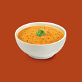 A bowl of pumpkin soup on a dark orange background 